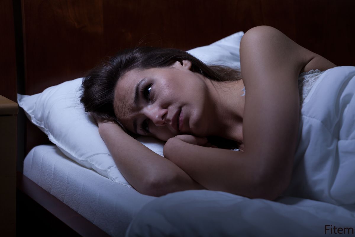Femme allongée dans son lit avec les yeux ouverts qui n'arrive pas à dormir car elle a essayer de faire du sport avant de dormir
