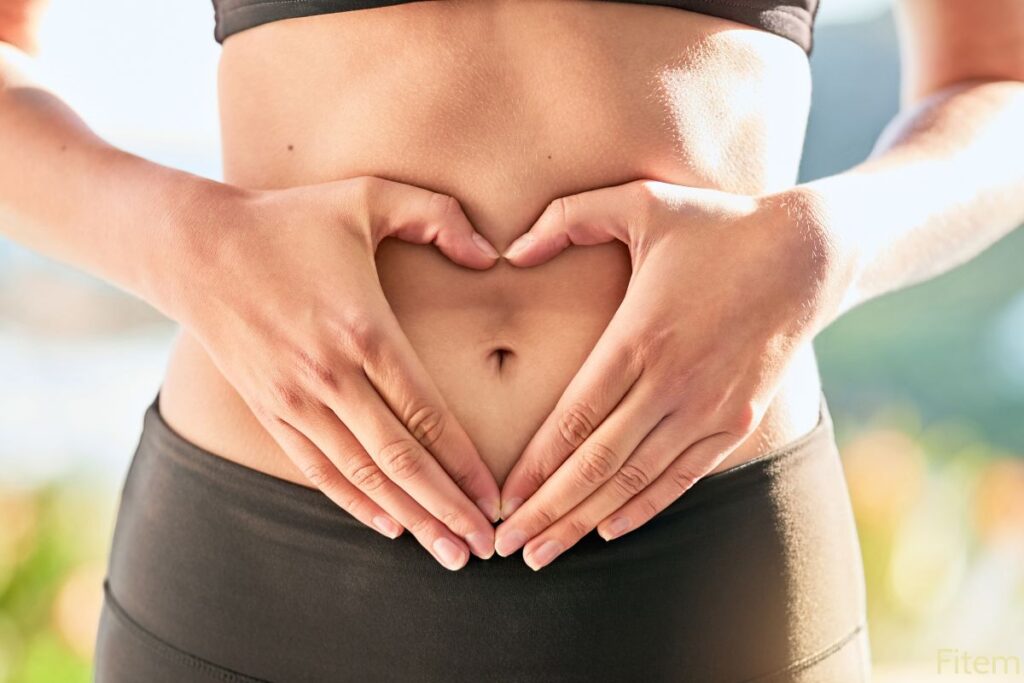 Personne qui pose ses mains en forme de coeur sur son ventre pour signifier qu'elle écoute son corps pour savoir quand est son meilleur moment pour faire du sport.