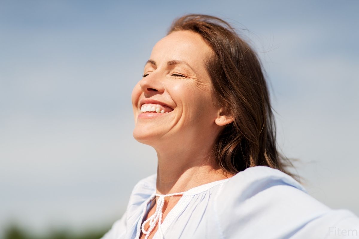 Une femme qui sourit et qui se rend des bienfaits du sport sur le moral et plus généralement des bienfaits du sport sur le cerveau